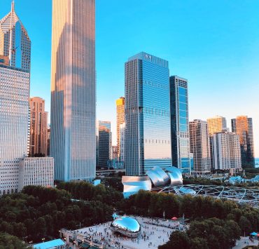 Photo image of the downtown landscape of chicago featuring tall buildings and the famous chicago cloud gate aka the bean in Millennium Park