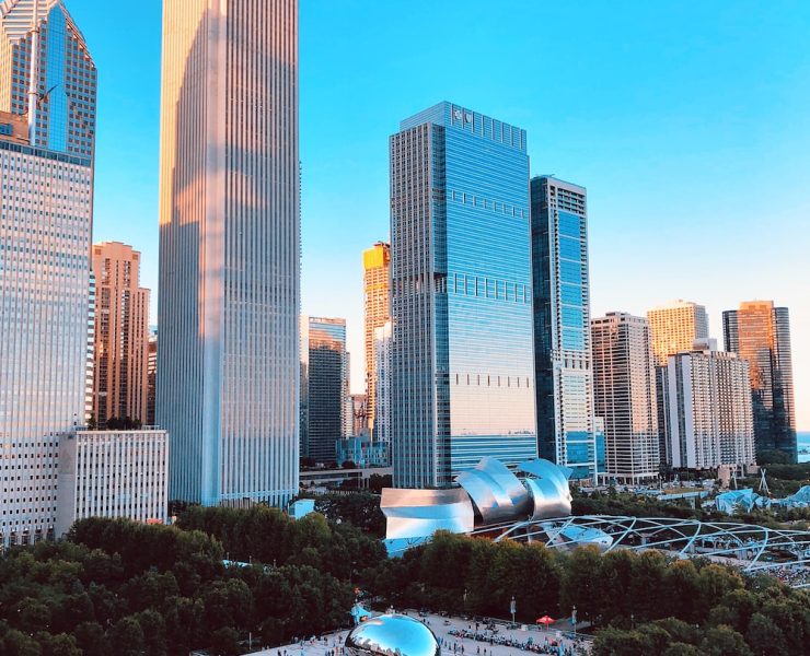 Photo image of the downtown landscape of chicago featuring tall buildings and the famous chicago cloud gate aka the bean in Millennium Park